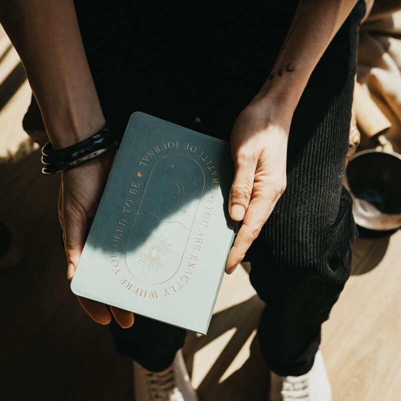 Un carnet de gratitude tenu entre les mains